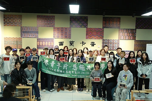 驻武汉办副主任白梅霞、西兰卡普传承人谭艳宾与同学们展示其手工作品并合影